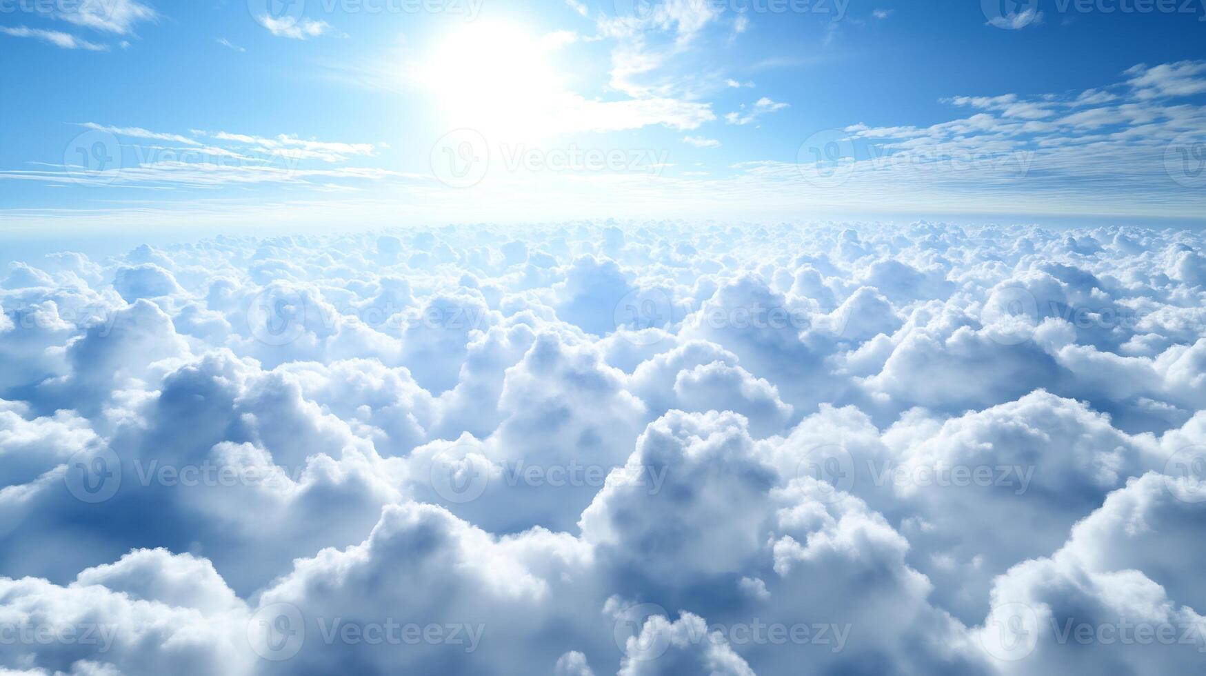 A breathtaking view of the sun shining brightly over a vast expanse of fluffy white clouds in a clear blue sky photo