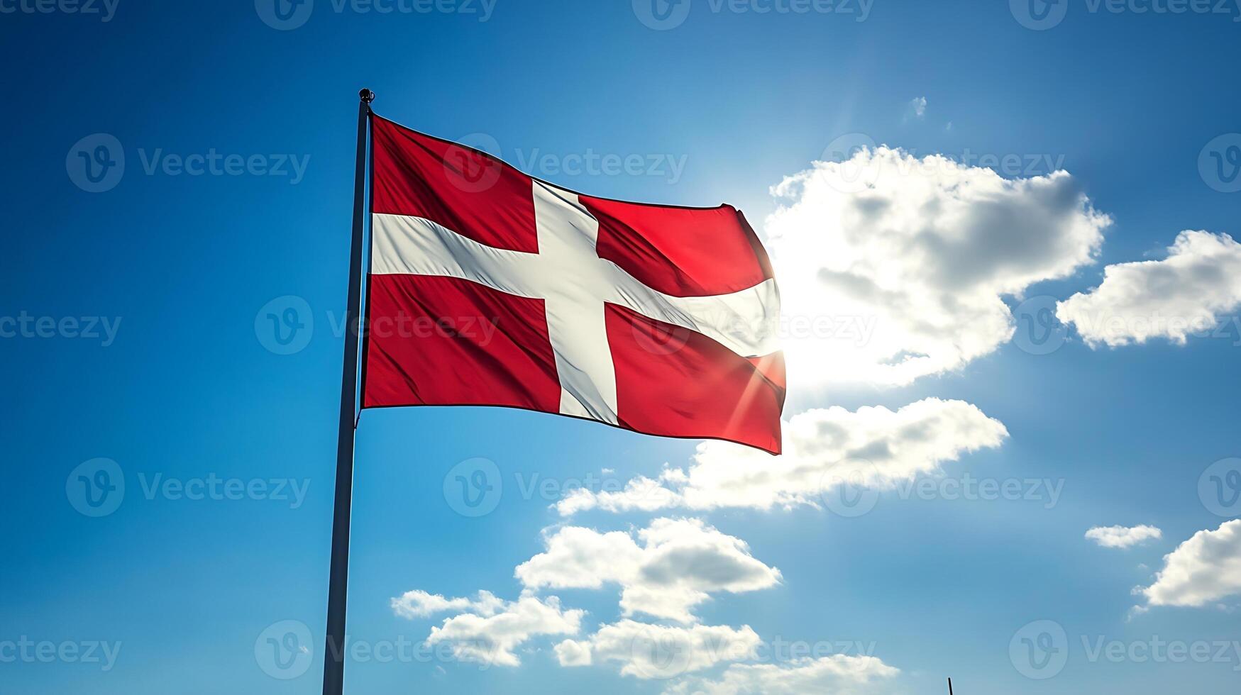 Danish Flag Waving on a Sunny Day with Vibrant Blue Sky and White Clouds photo