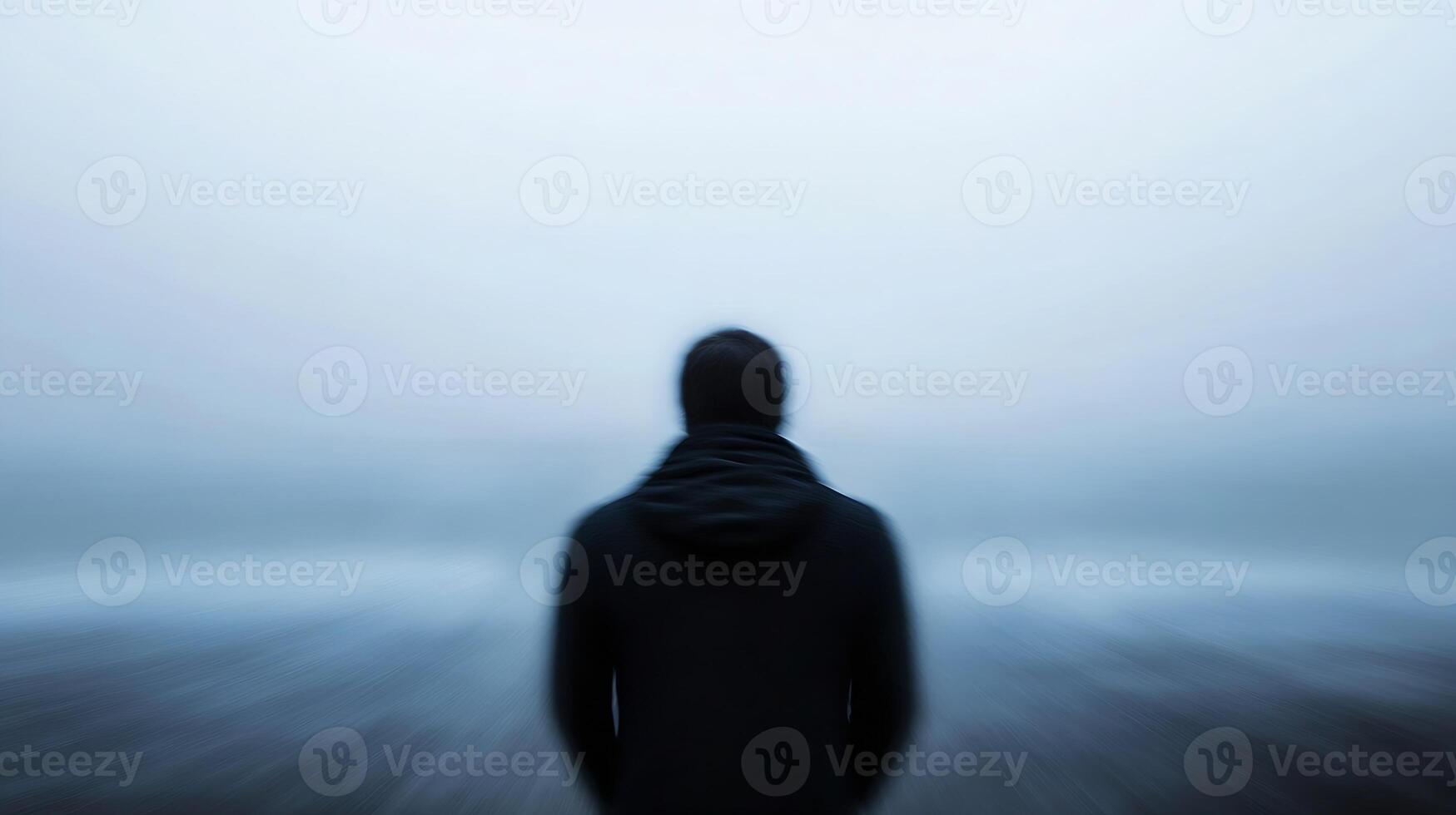 Solitary Figure in Blur Gazing at Ocean Creating Sense of Solitude and Reflection photo