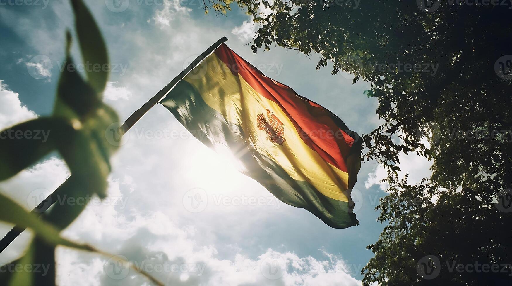 Bolivian flag waving in sunlight with tree foliage and sky background for patriotic imagery photo