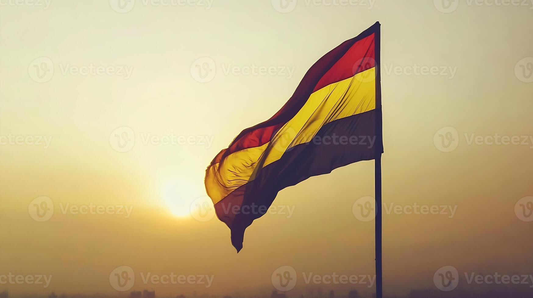 Dramatic sunset with vibrant yellow red and black flag waving in the breeze cityscape background photo
