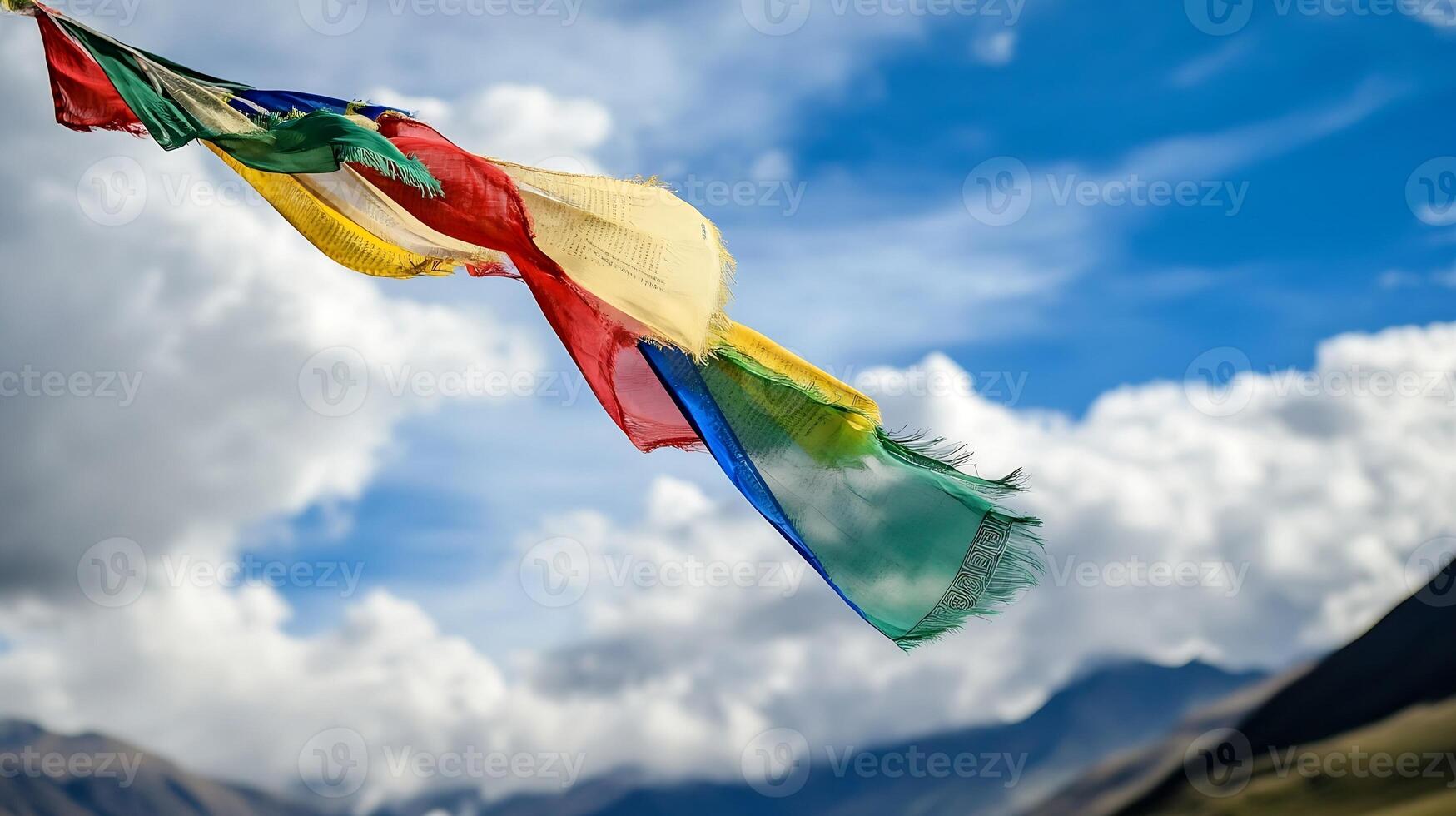 colorful tibetan prayer flag waving against blue sky and fluffy clouds symbolizing peace and spirituality photo