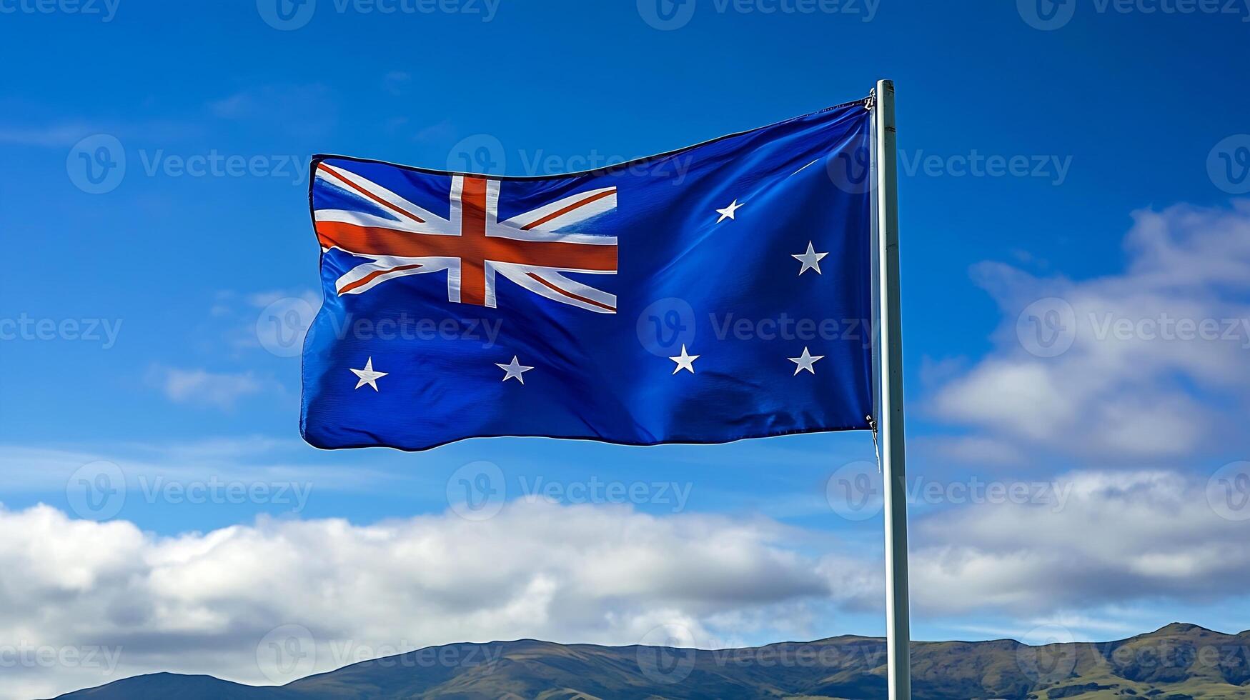 Australian Flag Proudly Waving in Clear Blue Sky with Scenic Mountainous Background photo