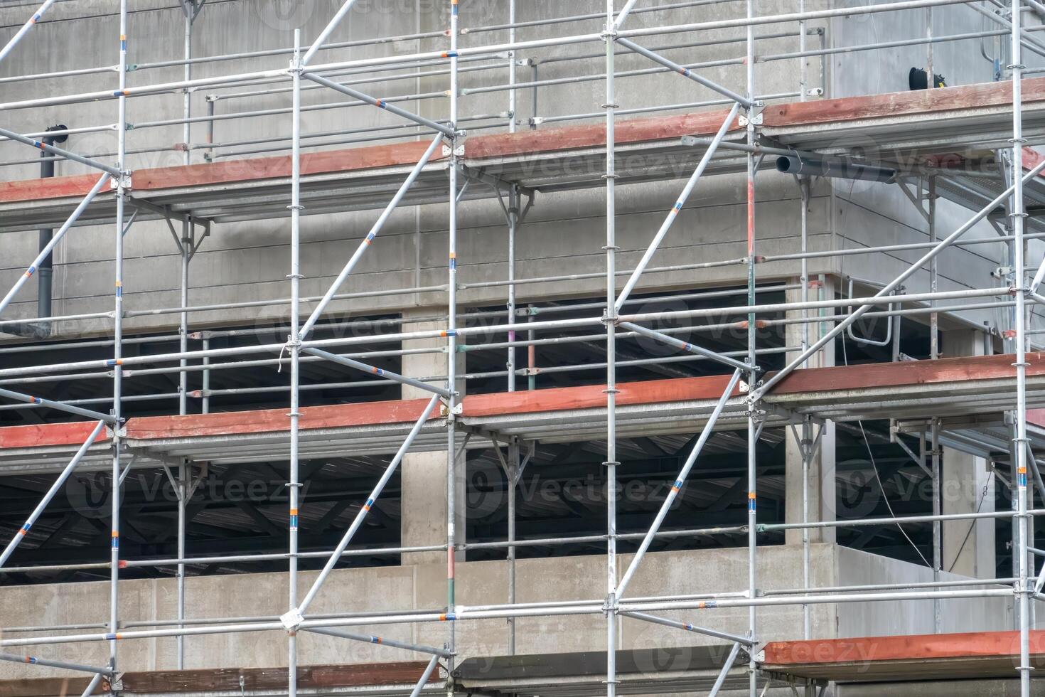 Scaffolding covering modern building during construction photo