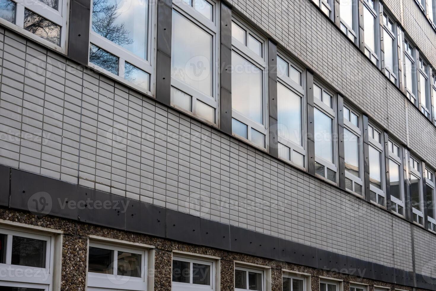 Modern building exterior showing multiple windows and grey bricks photo