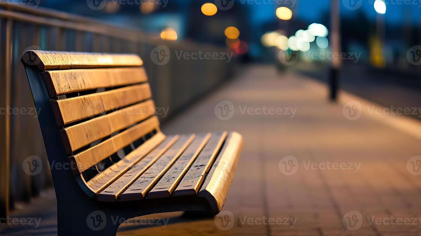 Tranquil Evening Shot of an Empty Wooden Bench on a Lit Urban Sidewalk photo