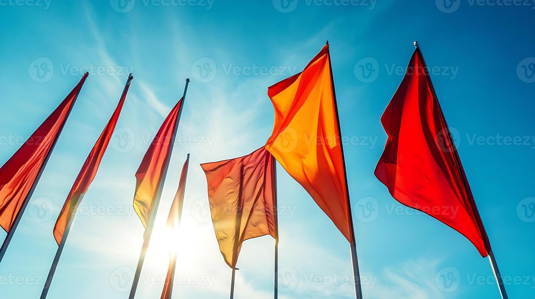 Vibrant Red and Orange Flags Against Blue Sky Symbolizing Celebration and Unity in a Bright Outdoor Setting photo