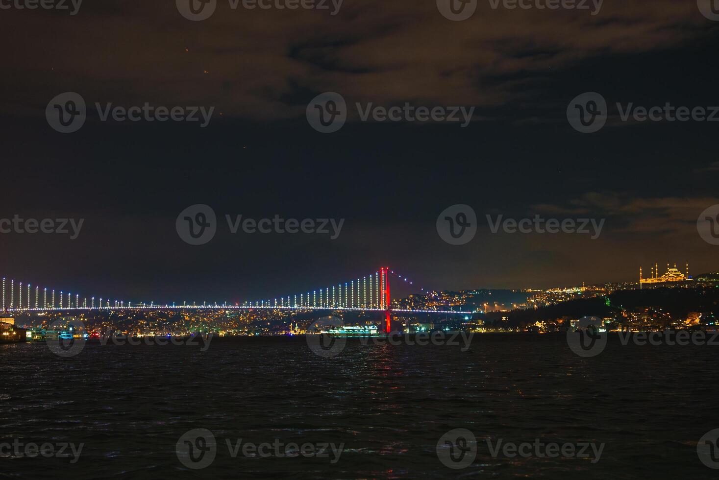 Bosphorus Bridge Illuminated at Night with Istanbul Skyline photo