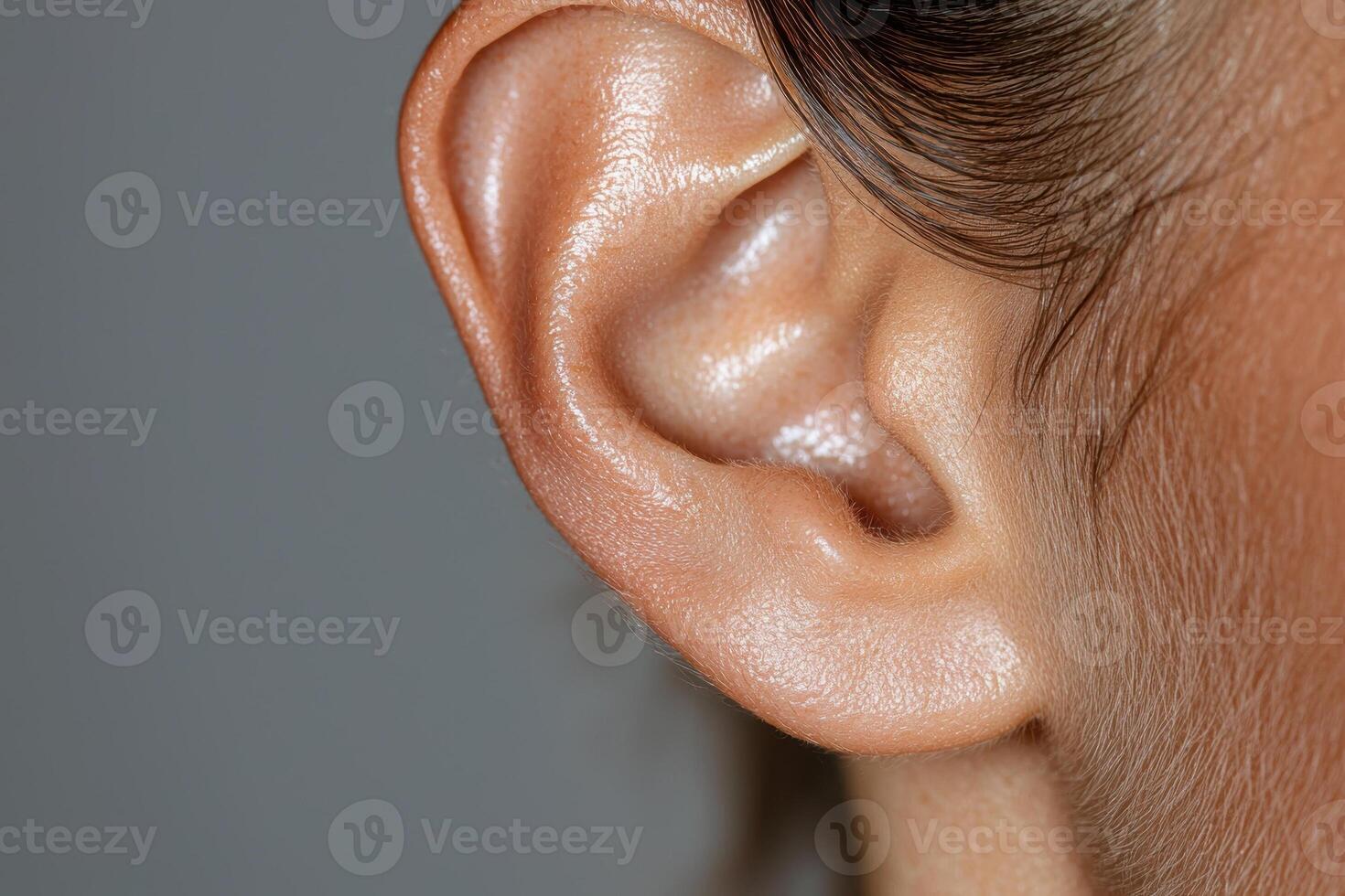 Close up of a persons ear, showing details of skin texture and hair photo