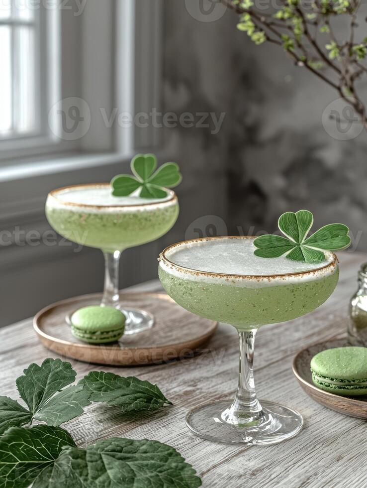 Two refreshing green cocktails garnished with shamrocks and served with pastel green macarons photo