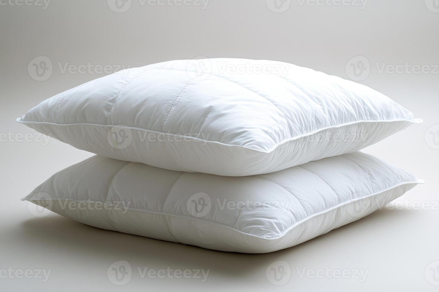 Two soft white pillows resting on each other on a gray background photo