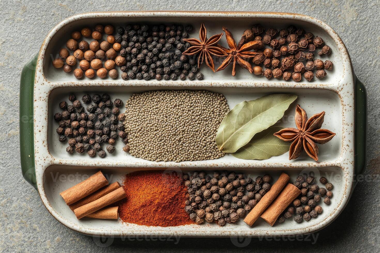Various aromatic spices and herbs beautifully arranged in a compartmentalized dish for culinary delights photo