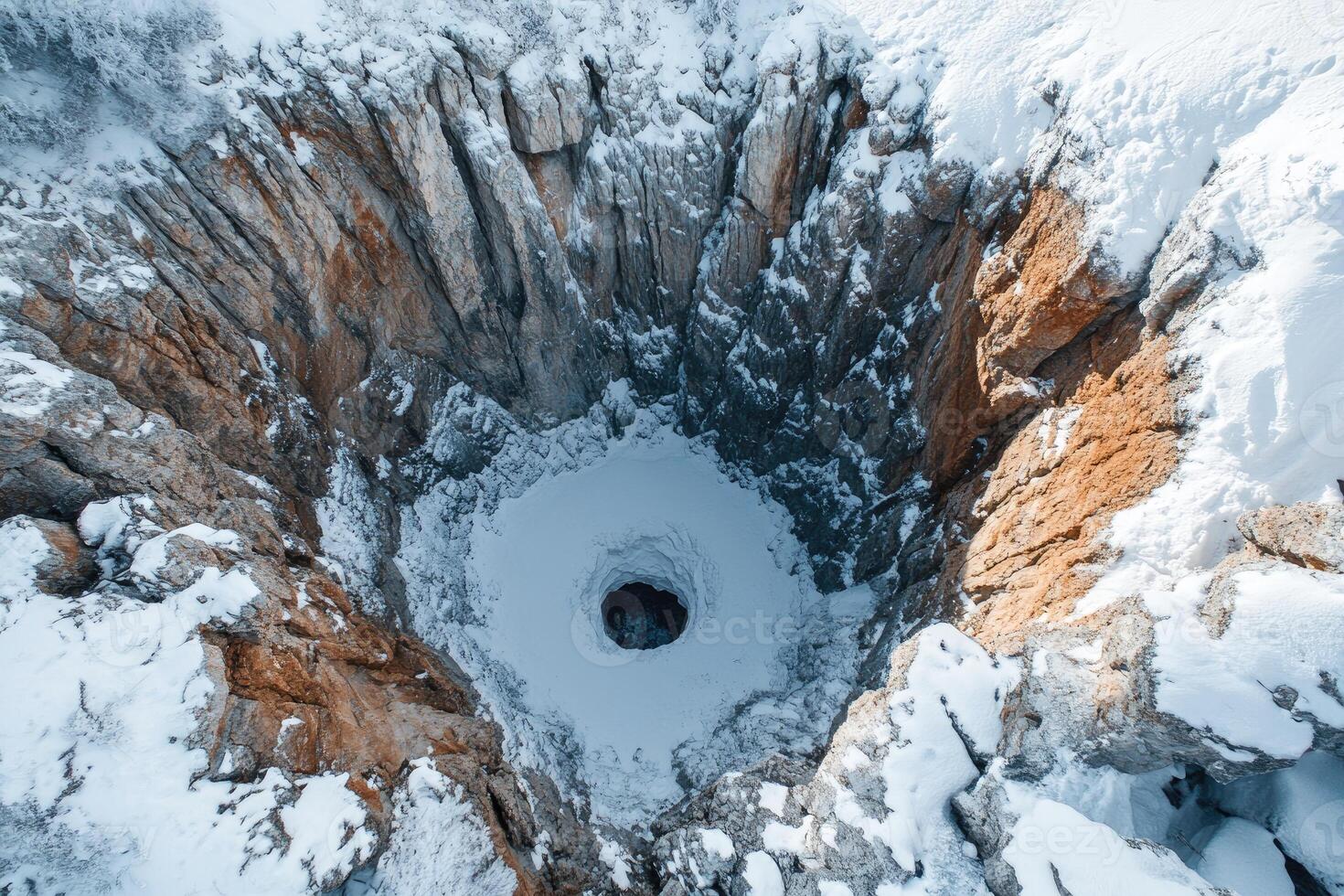Huge crater covered with snow in winter mountains landscape. photo