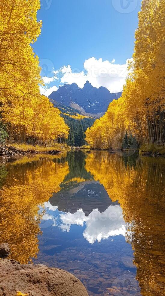 Maroon bells reflecting in a lake framed by golden aspen trees in autumn photo