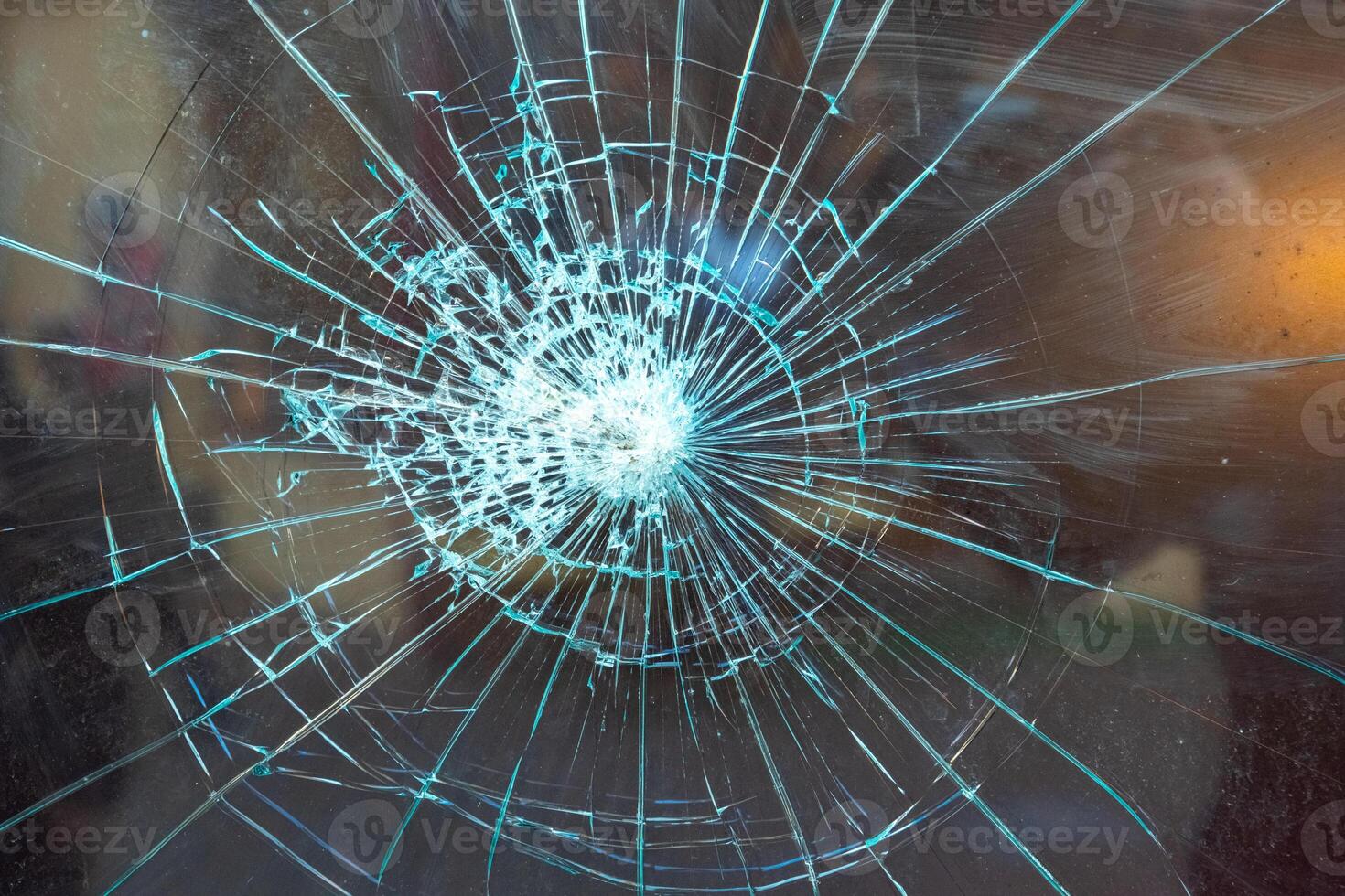 Cracked glass surface with intricate patterns illuminated by light, showcasing a dramatic burst effect photo