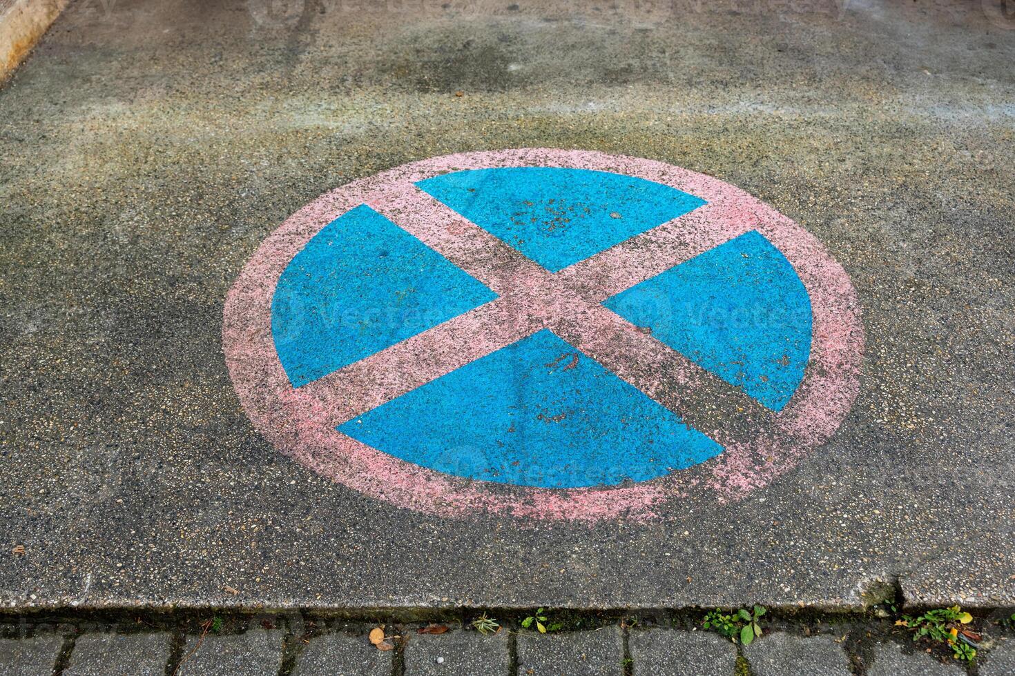 No parking symbol painted on a pavement in a city area during daytime photo