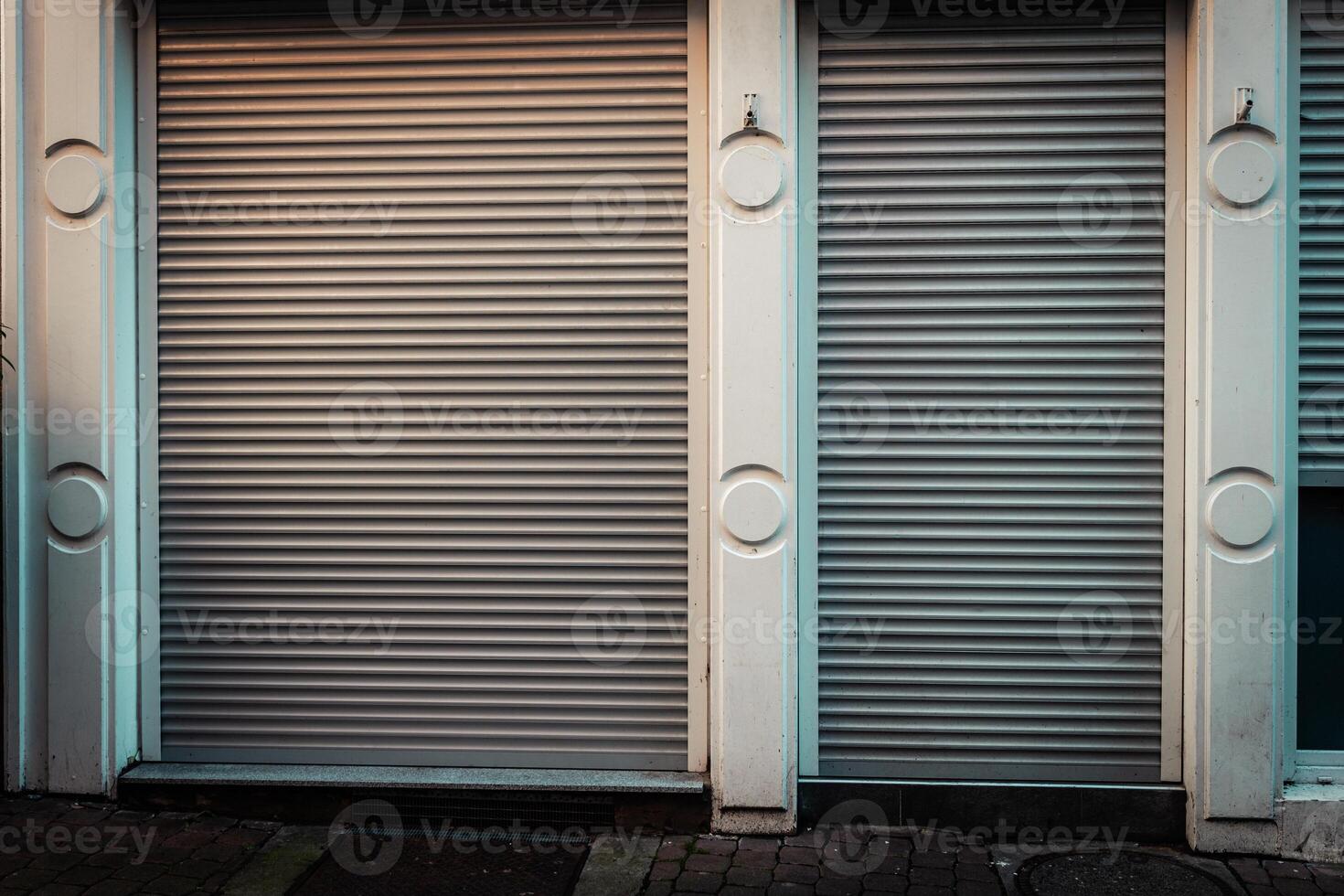 Closed shopfront in a quiet urban street illuminated by evening light photo