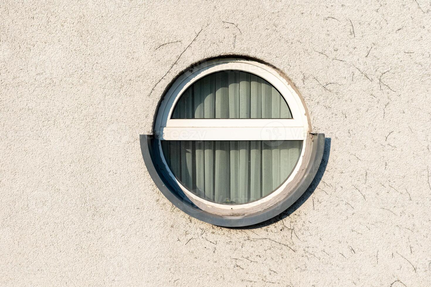 Unique circular window design on a textured wall showcasing modern architecture elements photo