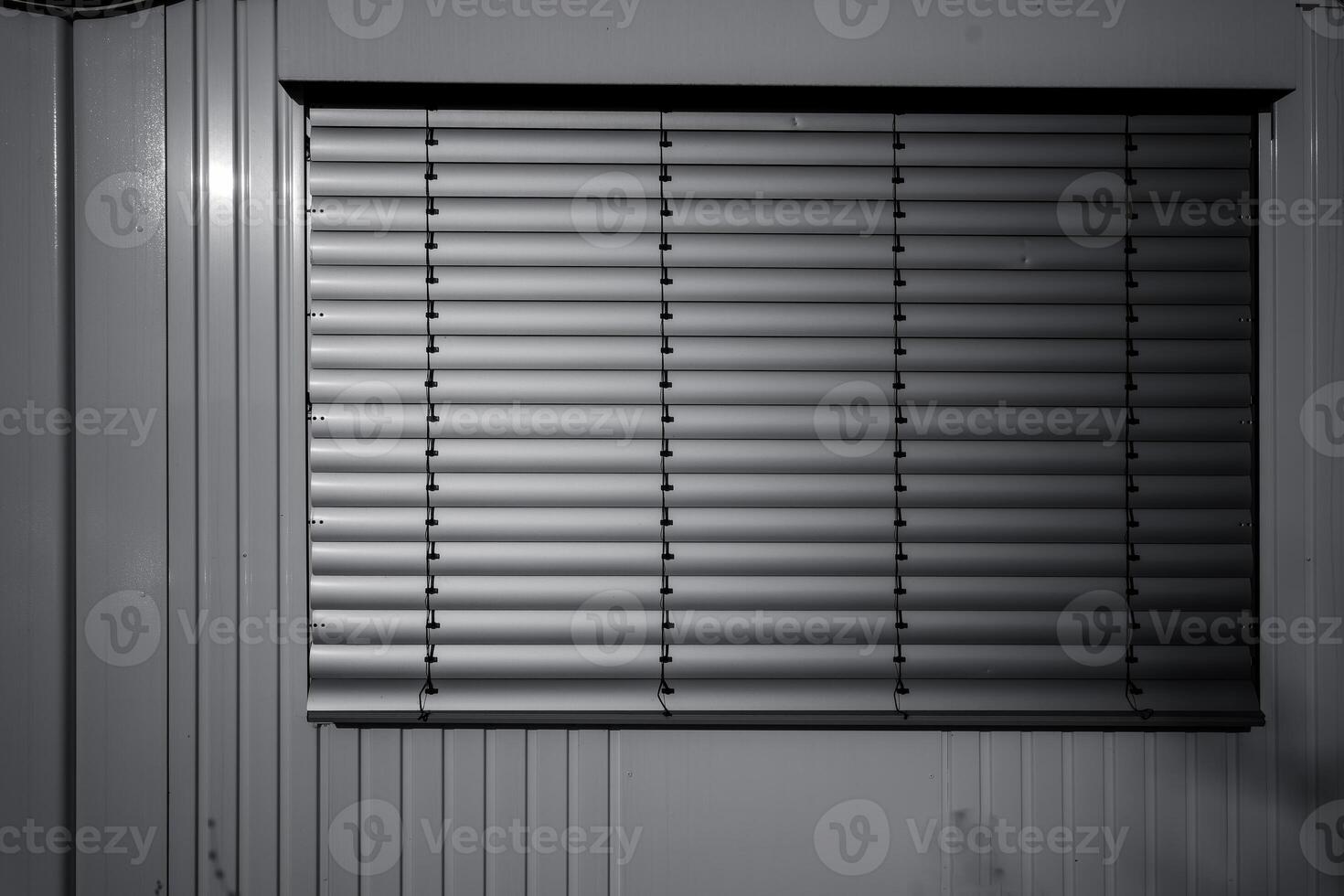 Light filtering through closed blinds in a quiet room during the early morning hours photo