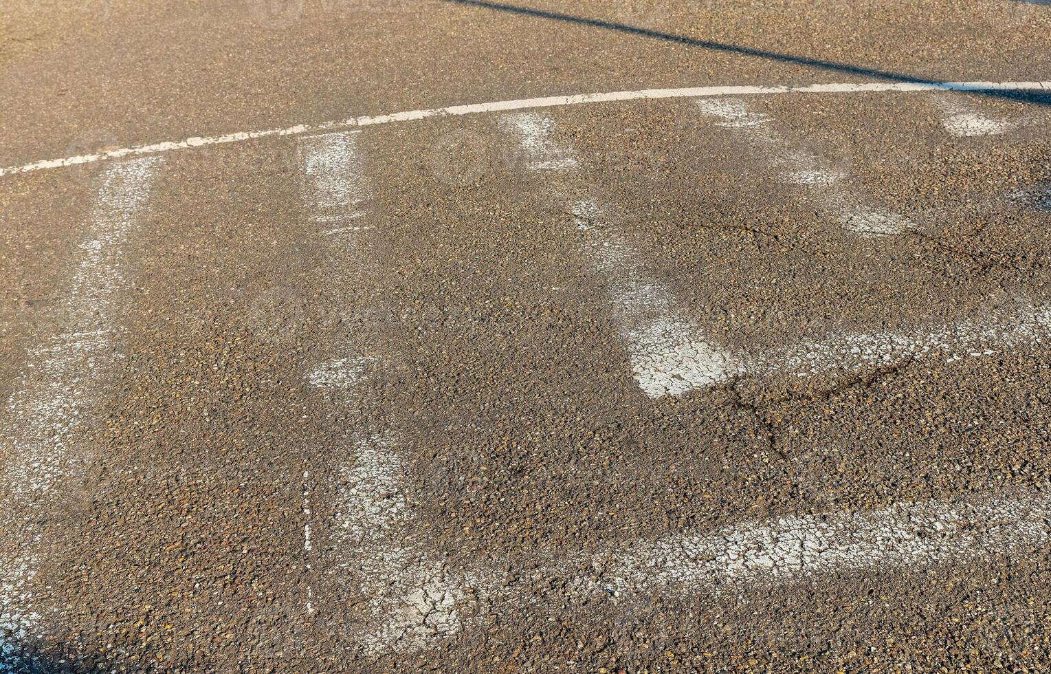 Freshly painted white markings on an asphalt surface in a community playground during the afternoon sun photo