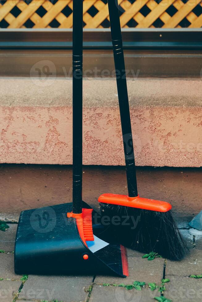 Cleaning tools arranged outside a building on a sunny day ready for use in maintenance work photo
