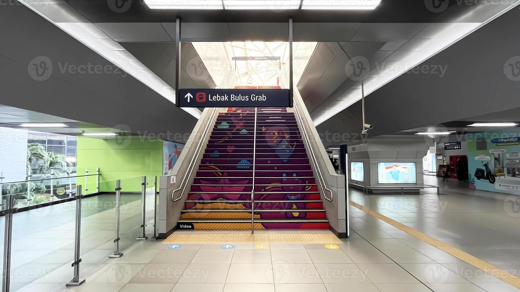 a stairway with colorful designs and a sign. A view inside of Blok M MRT Station in Jakarta photo