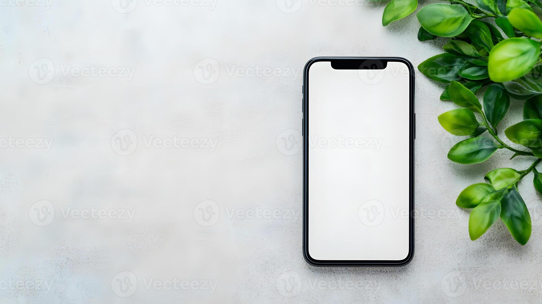 Smartphone with a white screen mockup displayed against a textured concrete wall, surrounded by modern tech gadgets photo