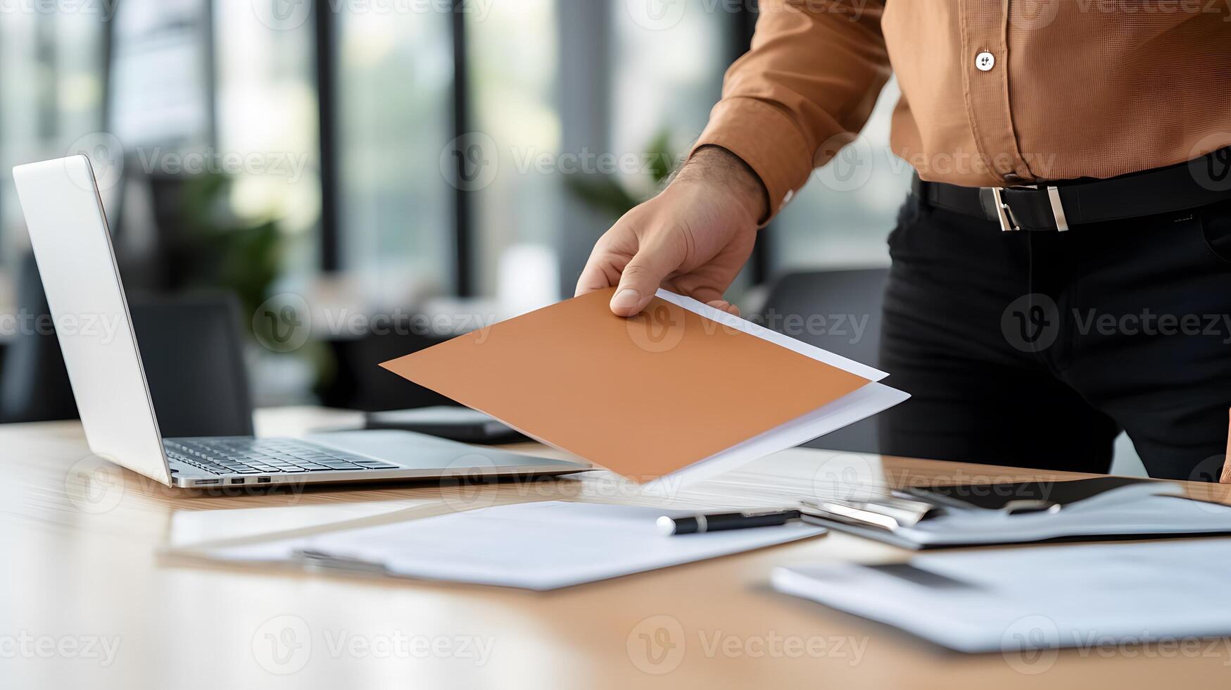 A new employee being shown around the office by a colleague during the onboarding process, with a laptop and documents on the desk photo