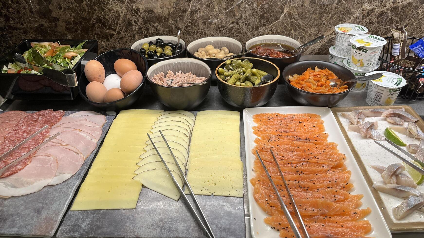 Vilnius, Lithuania. January 04, 2025. A breakfast buffet spread with a variety of fresh includes sliced meats, cheeses, smoked salmon, eggs, salads at the hotel restaurant photo