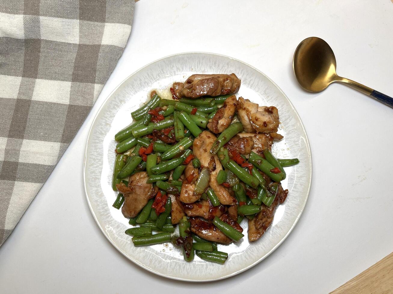 Stir fry spicy chicken and green beans served in a plate on white. Perfect for recipes, articles, catalogs or any commercial purpose. With copy space. photo