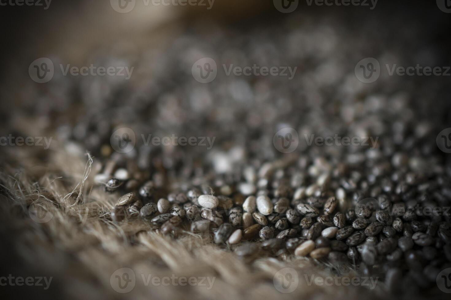 A closeup photo of a heap of chia seeds on a straw fabric