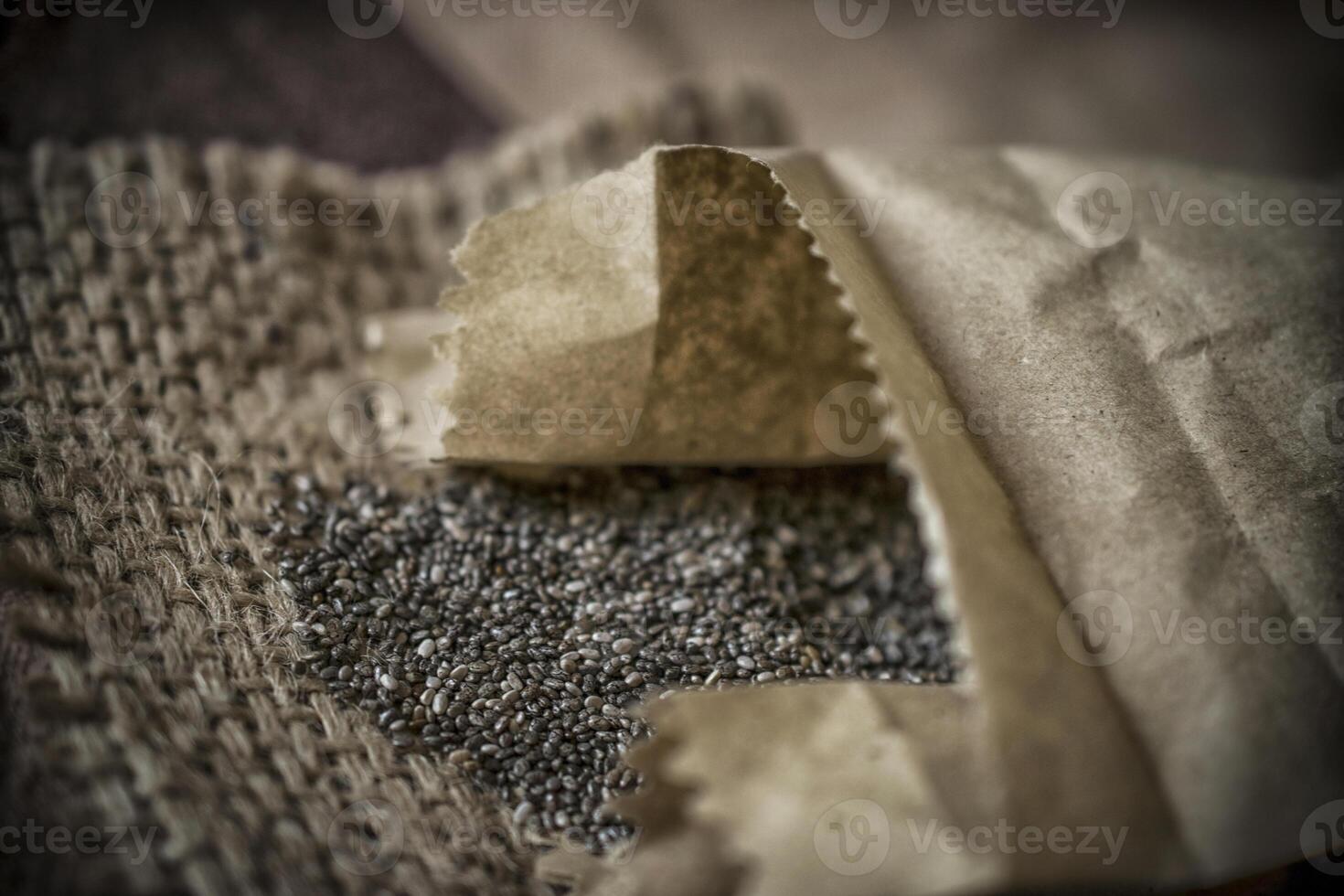 A closeup photo of heap of chia seeds on a straw fabric on a table