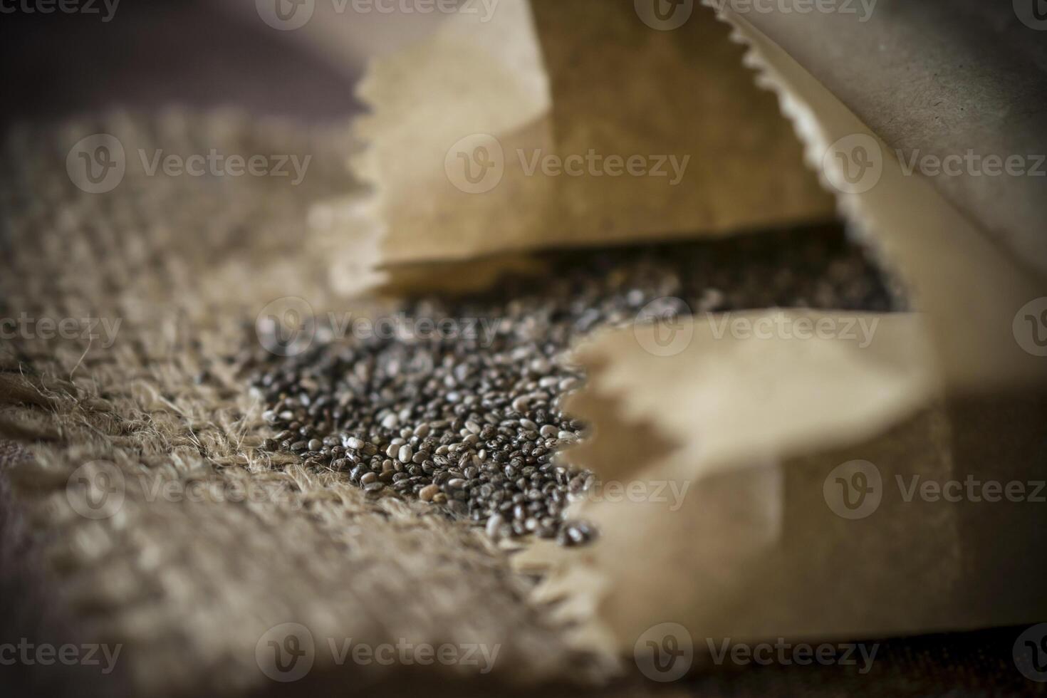A closeup photo of a heap of chia seeds on a straw fabric on a table