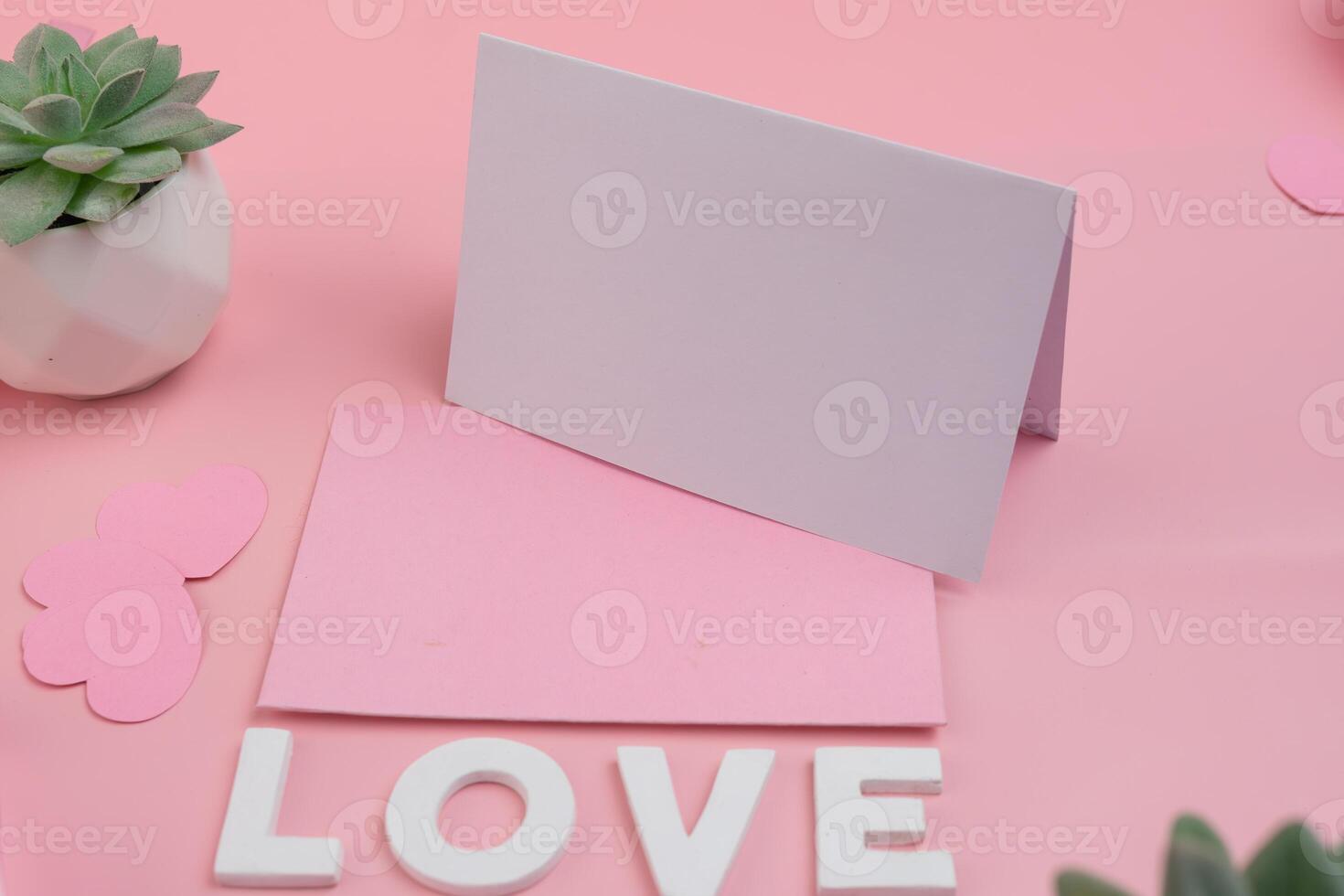 A light purple card standing on a pink card with the word LOVE spelled out below. invitation mockup design photo