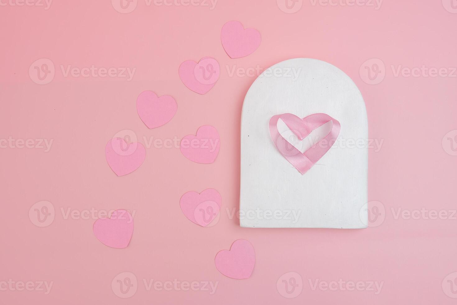 A white archway displays a pink ribbon heart surrounded by smaller pink hearts photo