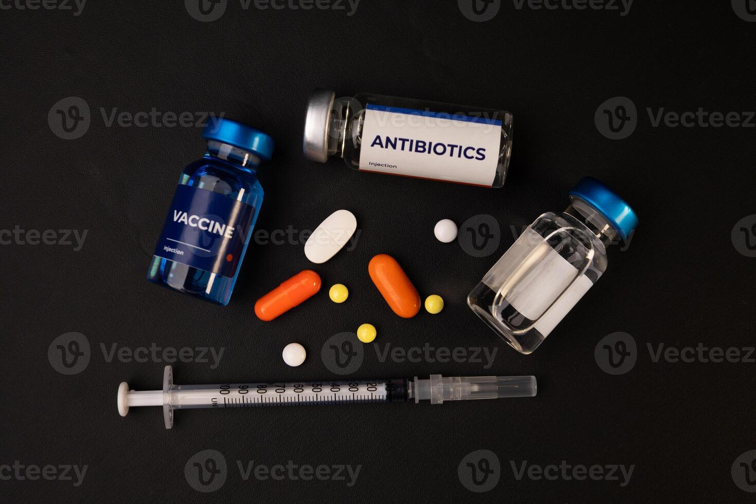 Vaccine antibiotics pills and a syringe lie on a dark surface. health and medical concept background photo