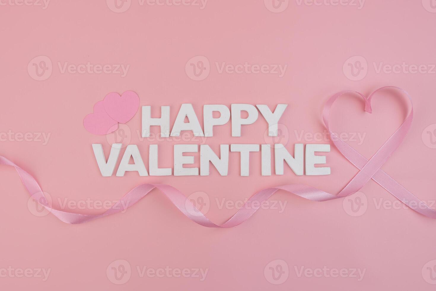 Happy Valentine spelled out with letters two small hearts and a ribbon forming a heart shape photo