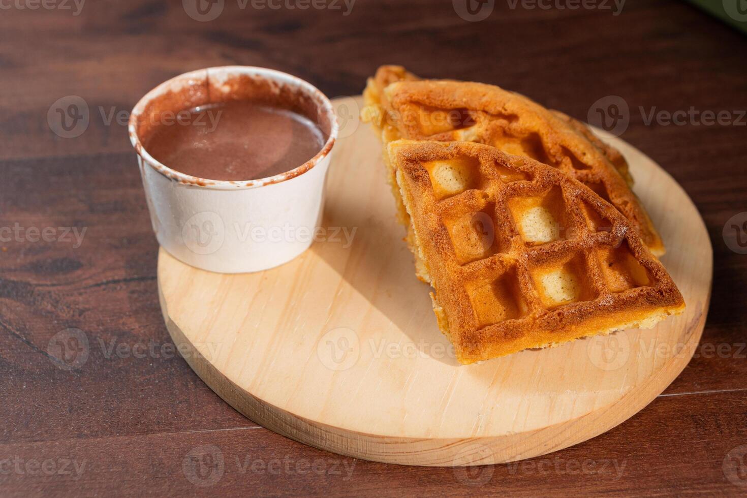 Waffle with Chocolate Sauce on Wooden Plate photo