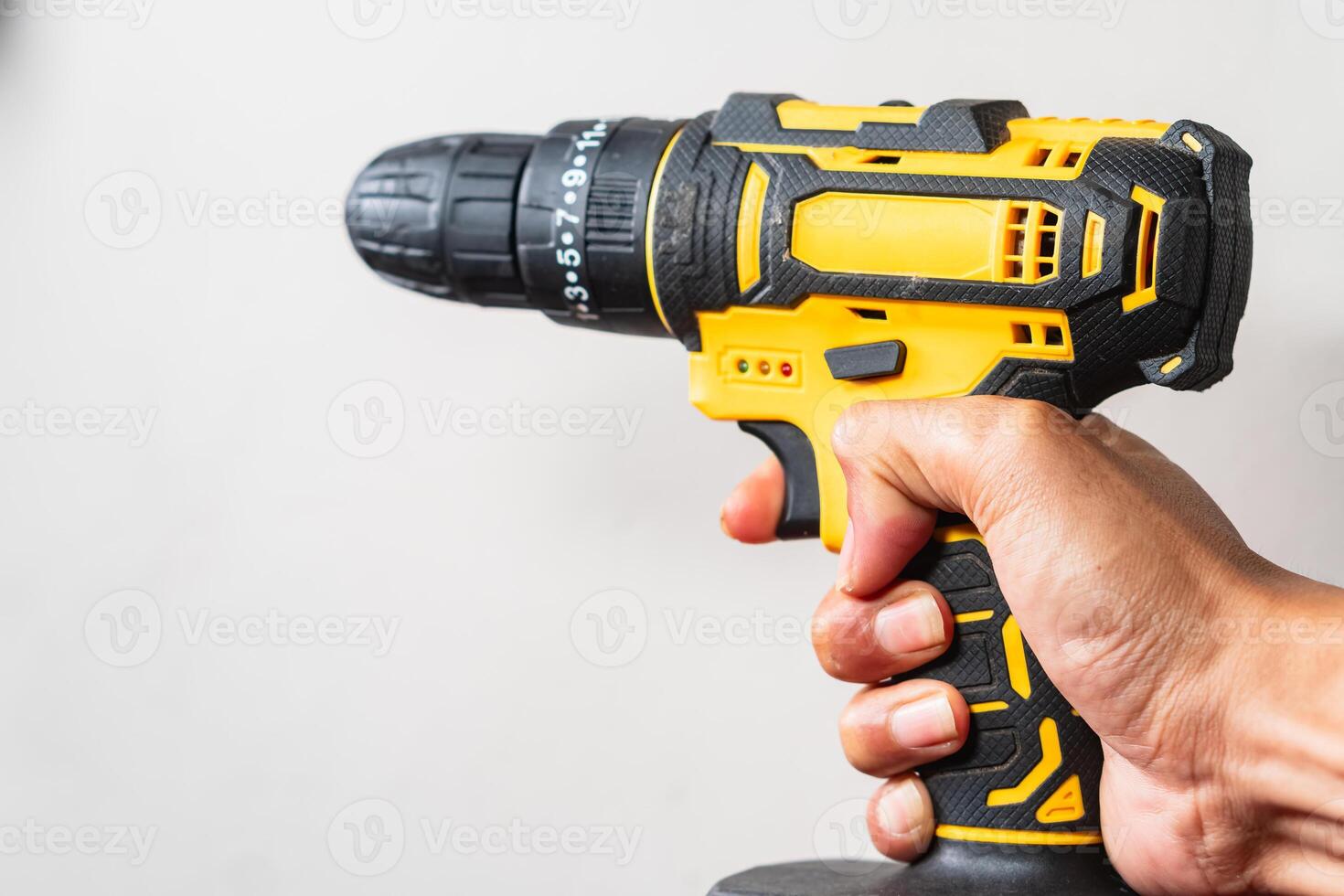Hand Holding a Yellow and Black Cordless Power Drill photo
