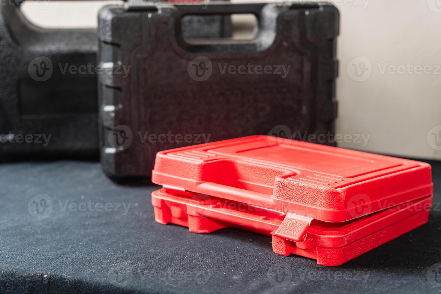 Stacked Red Tool Cases on Black Surface photo