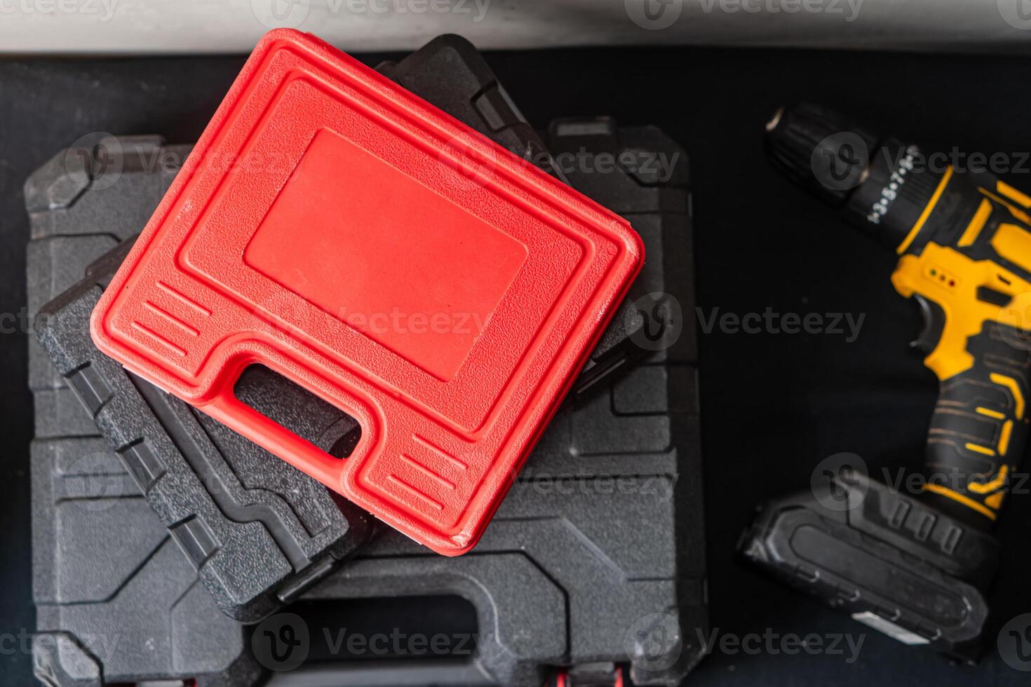 Red Tool Case on Black Toolboxes with Power Drill photo