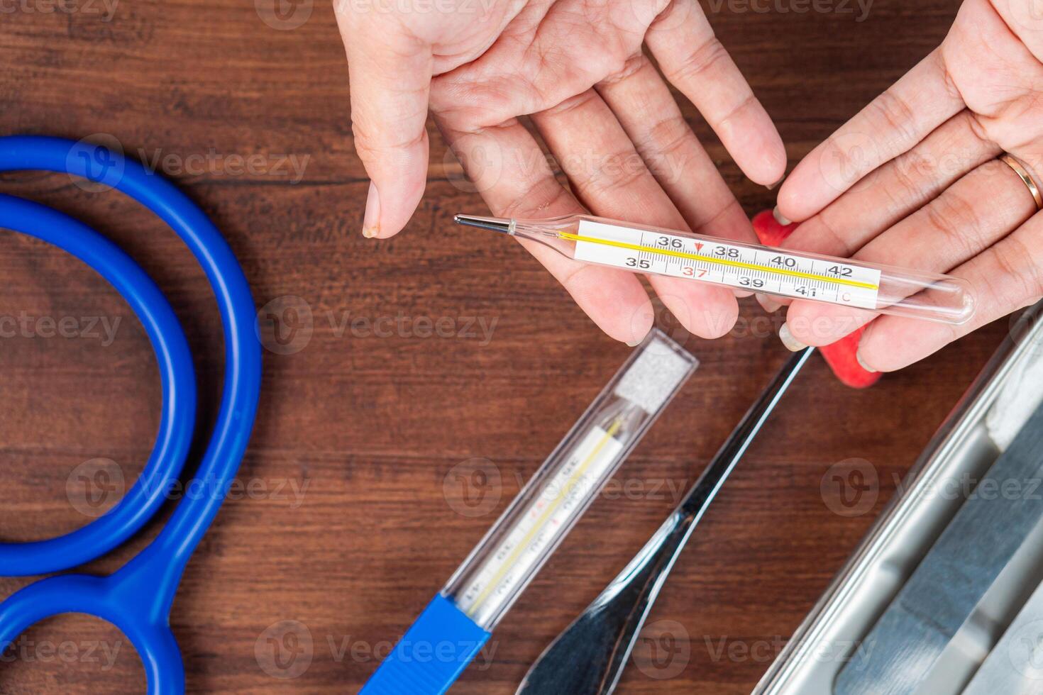 Hands Exchanging a Thermometer in a Medical Setting photo