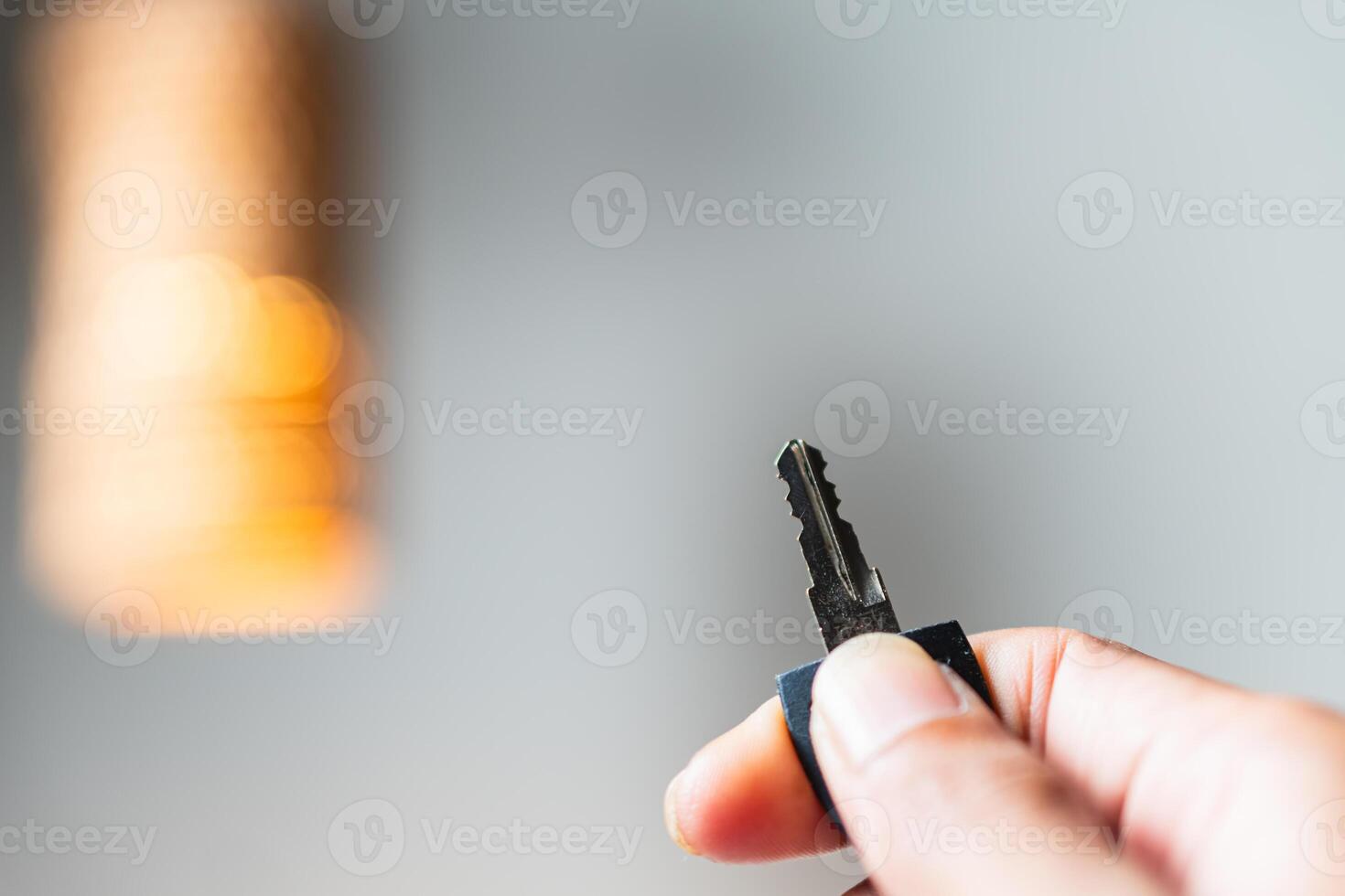Hand Holding a Key with Blurred Light Background photo