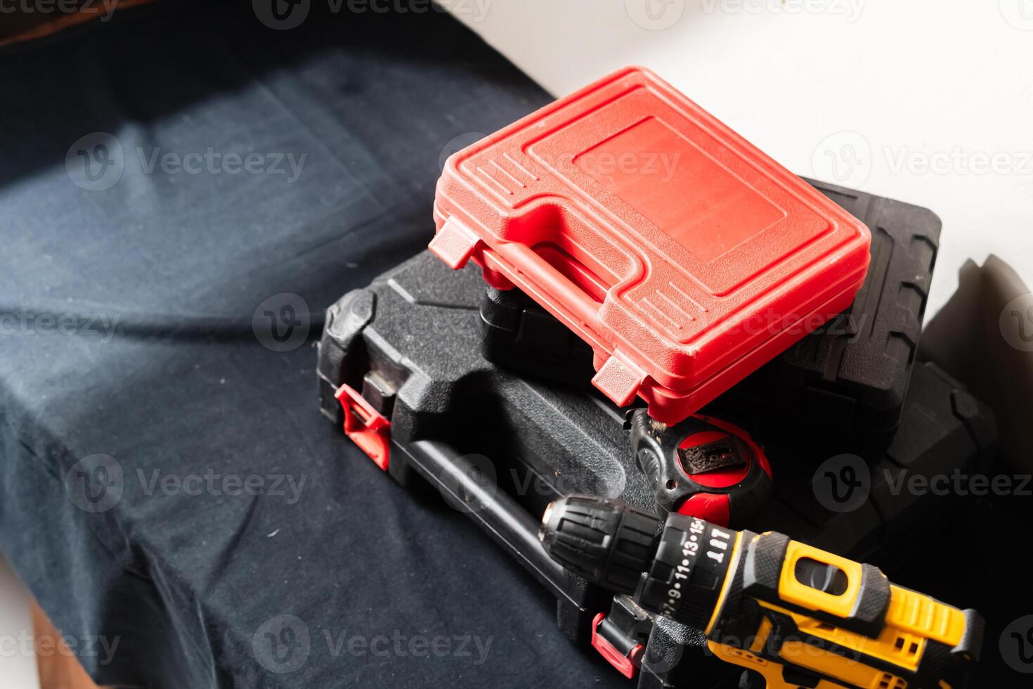 Collection of Toolboxes and Power Drill on Black Surface photo