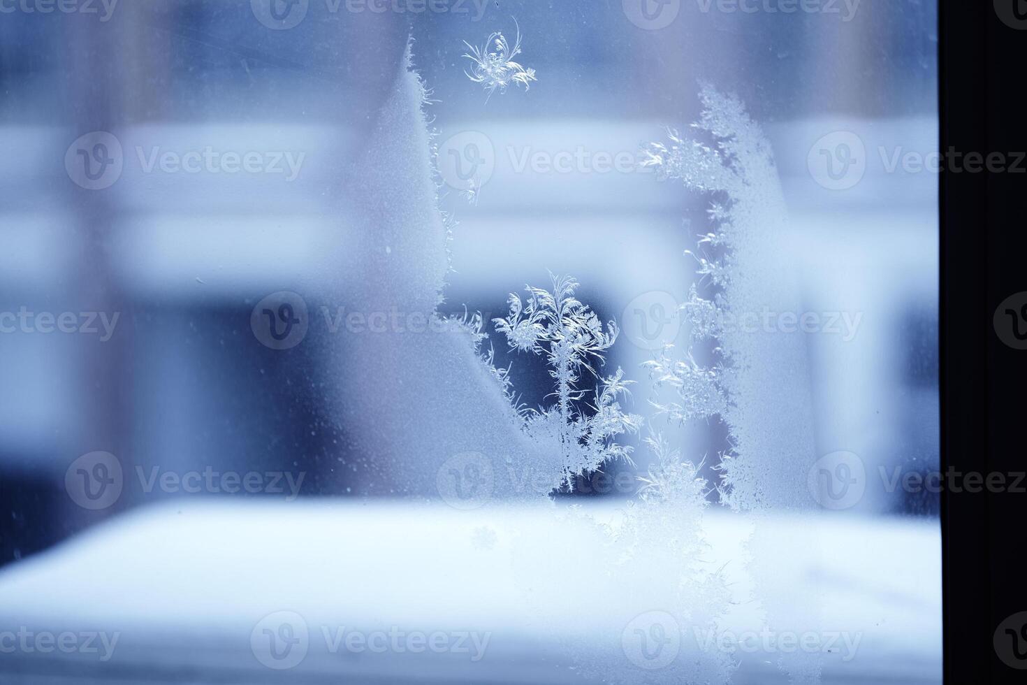 Close up of an abstract blurred freezing patterns on the window, glass with copy space. Blue blurred background photo