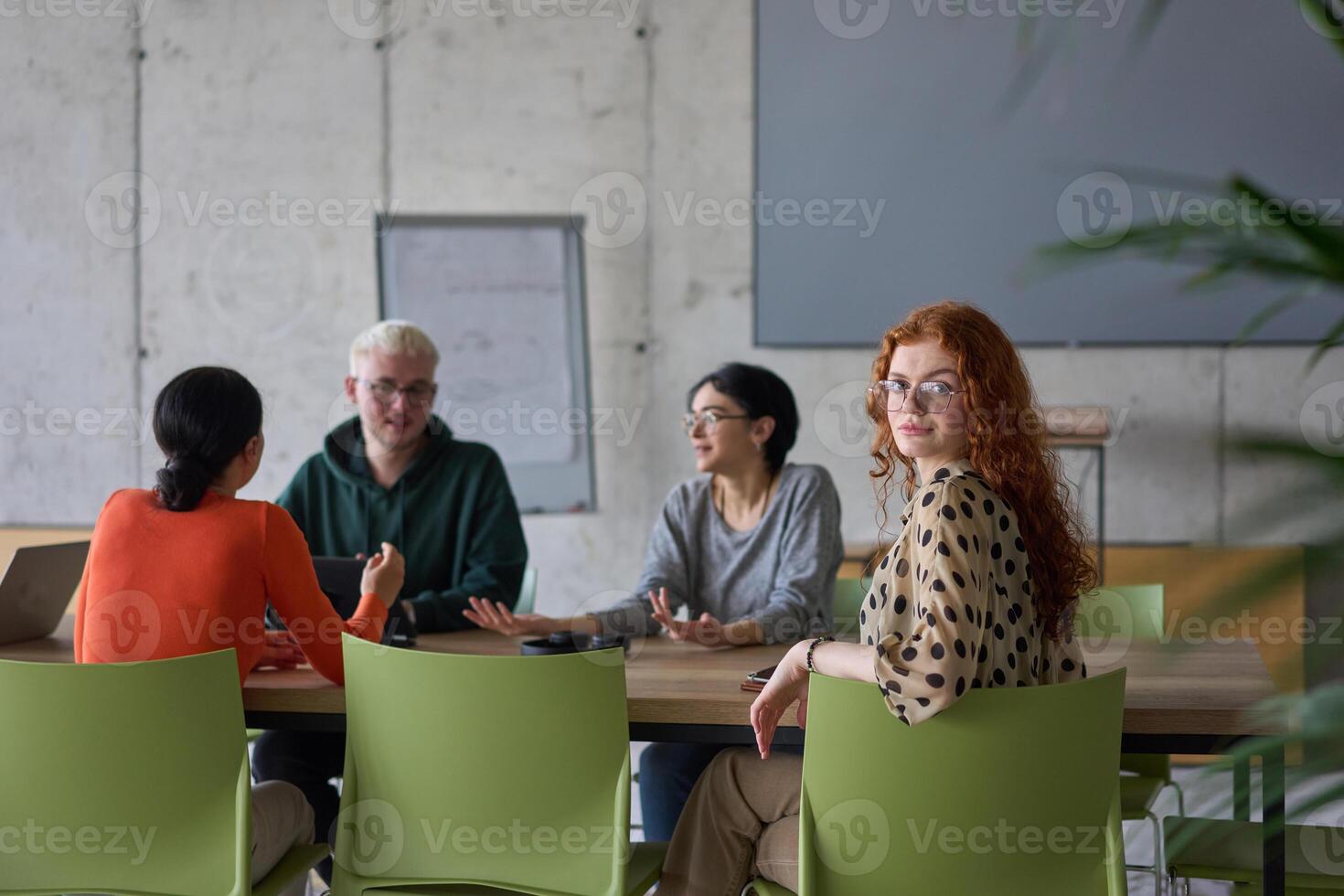 A young, diverse business team sitting together in a modern office, exchanging ideas and business plans, fostering collaboration and innovation for future success. photo
