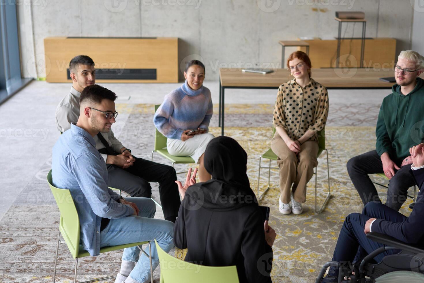 Corporate business team meeting with a manager or coach. Group of happy diverse, multiracial people sitting in a circle photo