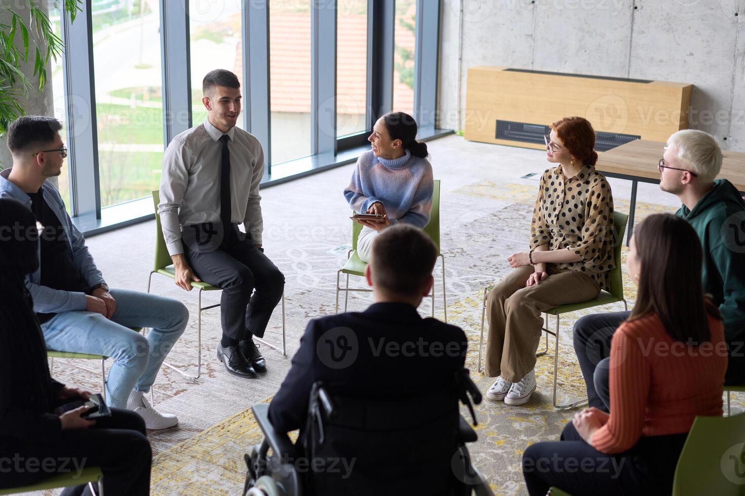Corporate business team meeting with a manager or coach. Group of happy diverse, multiracial people sitting in a circle photo