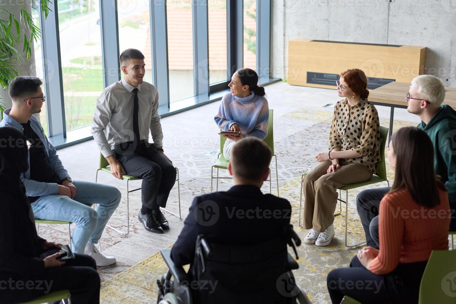 Corporate business team meeting with a manager or coach. Group of happy diverse, multiracial people sitting in a circle photo