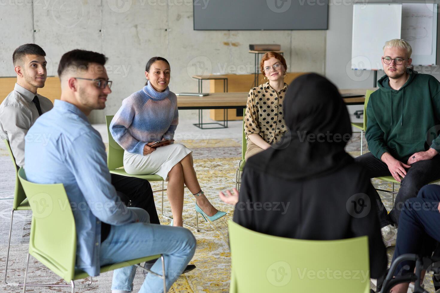 Corporate business team meeting with a manager or coach. Group of happy diverse, multiracial people sitting in a circle photo